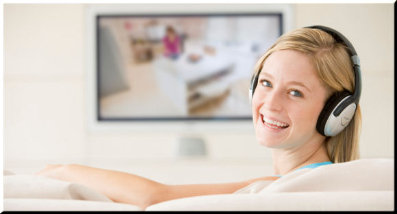Happy person watching television with headphones